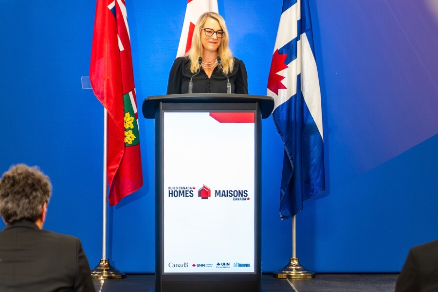 Julie Quenneville at the podium for the social medicine announcement speaking to the audience.