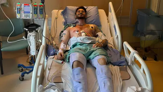 Joseph Careri at UHN's Ajmera Transplant Centre laying in bed while connected to medical devices and machines.